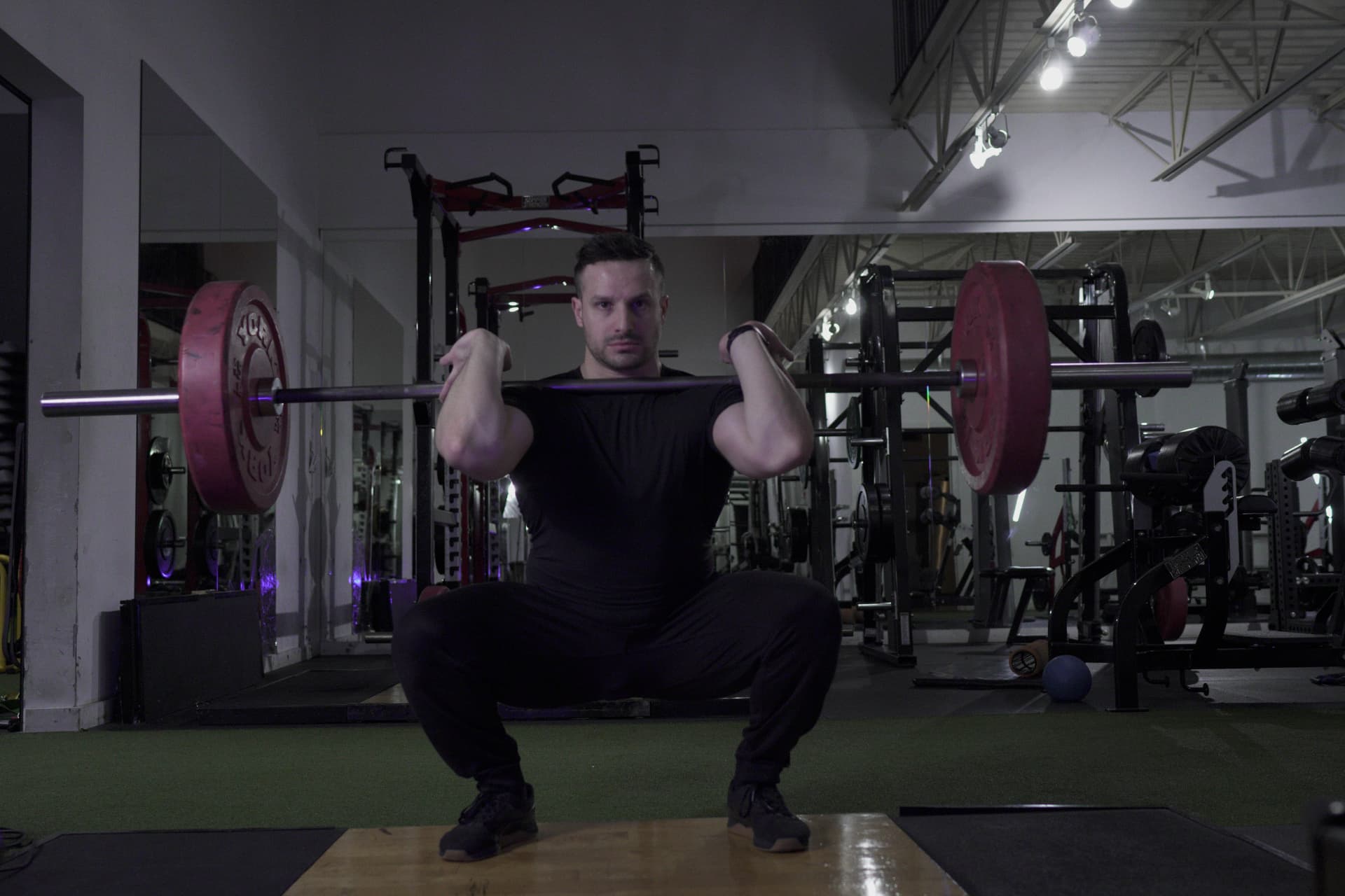 Comega coach performing a barbell front squat